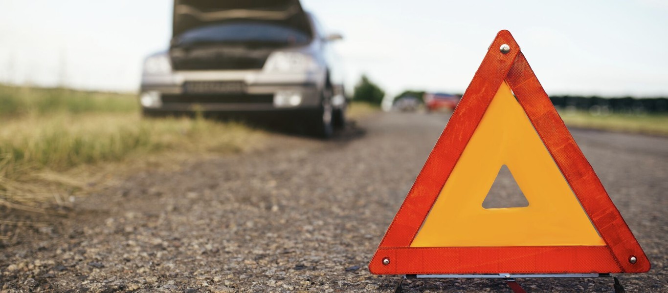 Roadside assistance emergency warning triangle with broken down car in West Babylon, NY